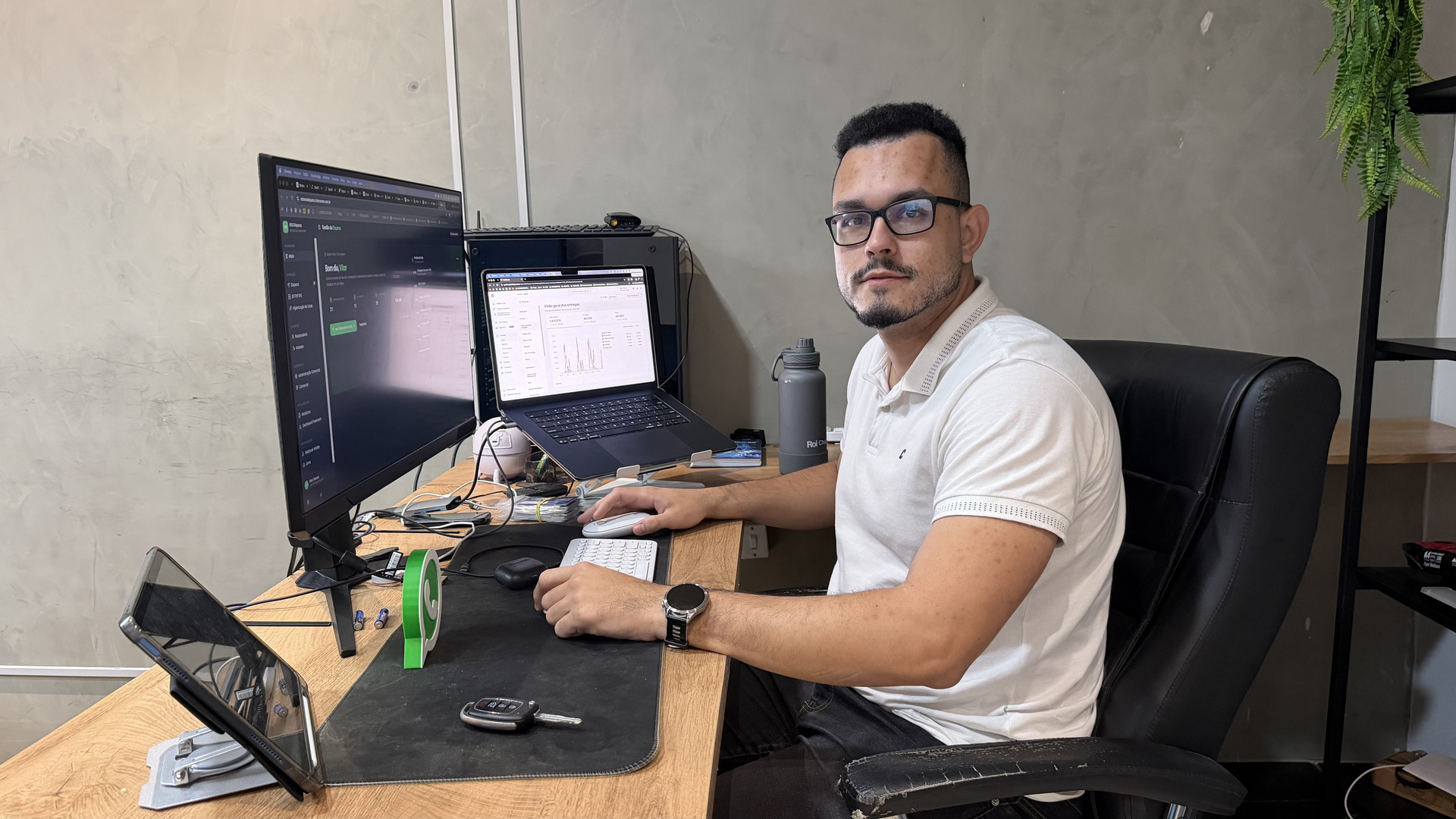 Vitor Soares em sua estação de trabalho com dashboards de operações WhatsApp
